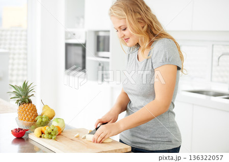 Woman, cooking and fruit for health food and nutrition for weight loss diet and health at home. Kitchen, organic fruits and cut banana in a house with breakfast and nutritionist in the morning 136322057