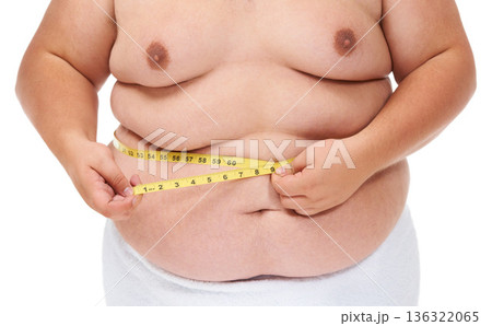 Overweight, tape measure and man checking wellness progress and weight loss goal in studio. White background, hands and model with plus size stomach with body problem and health issue with towel Overweight, tape measure and man checking wellness progress and weight loss goal in studio. White background, hands and model with plus size stomach with body problem and health issue with towel 136322065