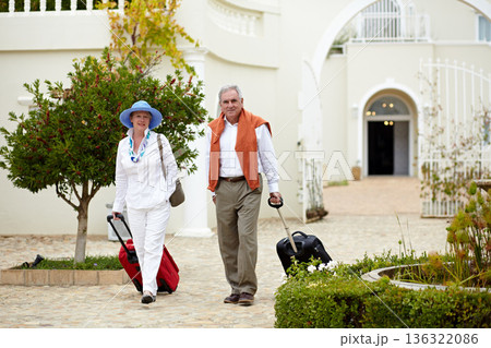 Hotel, vacation and elderly couple walking with suitcase in a holiday location happy in retirement and travel together. Bag, smile and senior people on a journey or man and woman walk in happiness Hotel, vacation and elderly couple walking with suitcase in a holiday location happy in retirement and travel together. Bag, smile and senior people on a journey or man and woman walk in happiness 136322086