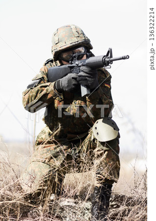 Soldier man, machine gun and outdoor with aim, field and nature for war, fight and army in countryside. Military service, battlefield and agent with weapon, gear and helmet for conflict in Ukraine Soldier man, machine gun and outdoor with aim, field and nature for war, fight and army in countryside. Military service, battlefield and agent with weapon, gear and helmet for conflict in Ukraine 136322214