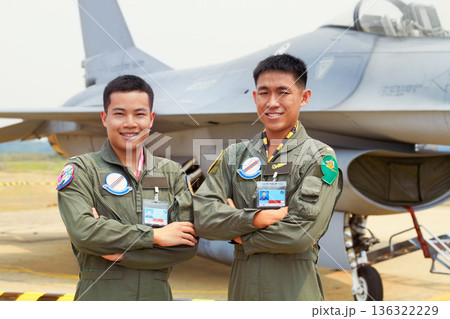 Portrait of men, fighter pilot team in military with jet and smile at airforce base with arms crossed in Korea. Freedom, transport and proud Asian soldier with airplane, confident and service in army 136322229