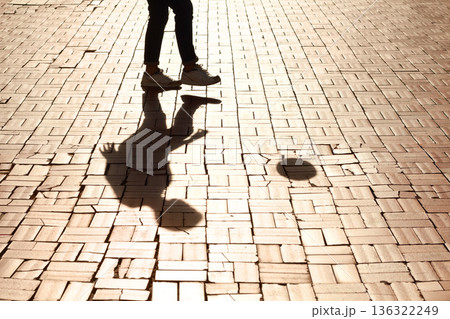 Sports, soccer and man shadow with a ball training for a skill, trick or stunt on a pavement. Silhouette, football and legs of a male person practicing for a game, match or tournament in the city. Sports, soccer and man shadow with a ball training for a skill, trick or stunt on a pavement. Silhouette, football and legs of a male person practicing for a game, match or tournament in the city. 136322249