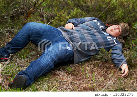 Drunk, sleeping and hangover with a plus size man lying outdoor on the grass or ground after a party. Festival, alcohol and tired with a young male person asleep on a field or lawn in the morning Drunk, sleeping and hangover with a plus size man lying outdoor on the grass or ground after a party. Festival, alcohol and tired with a young male person asleep on a field or lawn in the morning 136322279