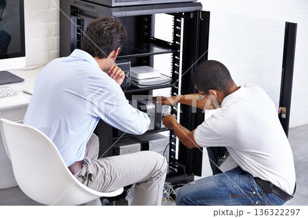 Server room, man and technician working with electronics for hardware maintenance of glitch in office. IT support, worker and electrical engineer fixing internet connection for information technology 136322297