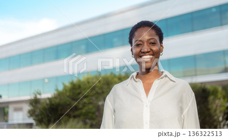 Smiling black businesswoman in white shirt Smiling black businesswoman in white shirt 136322513