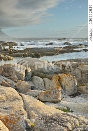 Ocean, rocks and landscape with beach and travel, waves and summer vacation outdoor. Environment, sea view and seaside location with tropical destination and journey on island, nature and adventure 136322636