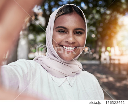 Selfie, happy and portrait of Muslim woman in park for holiday, freedom and relax outdoors. Social media, hijab and face of Islamic female person with smile for picture, memories and post in nature Selfie, happy and portrait of Muslim woman in park for holiday, freedom and relax outdoors. Social media, hijab and face of Islamic female person with smile for picture, memories and post in nature 136322661