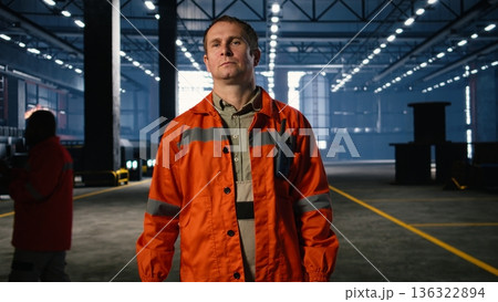 Industrial supervisor walking around factory floor and overseeing assembly teams with equipment, reinforcing engineering safety, plant power and efficient steel manufacture. 136322894