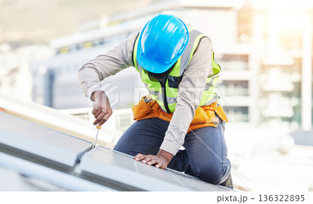 Man, technician and screwdriver for solar panel installation on rooftop in the city for renewable energy. Male person, engineer or contractor working on roof in sun for installing eco friendly power 136322895