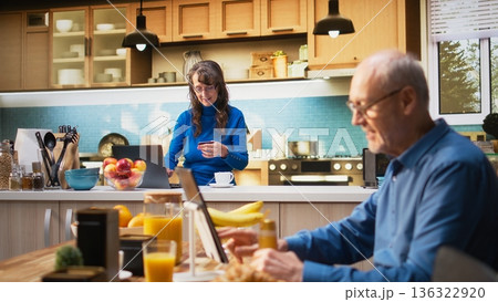 Senior woman entering card numbers for online grocery shopping on website, buying fresh food and other supermarket products. Pensioner at the counter reviewing credentials on app. Camera A. 136322920