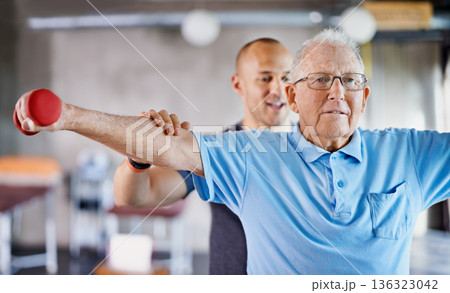 Physiotherapist, senior man and weight training for health and wellness therapy in retirement. Healthcare, physio and workout for recovery with a dumbbell for medical excuse and elderly male person Physiotherapist, senior man and weight training for health and wellness therapy in retirement. Healthcare, physio and workout for recovery with a dumbbell for medical excuse and elderly male person 136323042