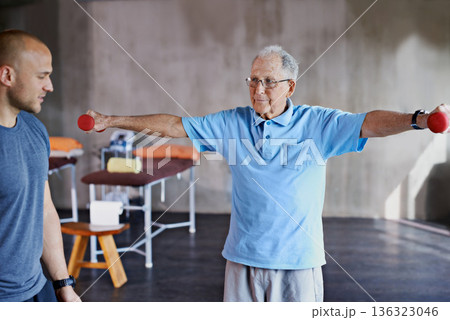 Physiotherapist help, senior man and weight training for health and wellness therapy in retirement. Healthcare, physio and workout for recovery with a dumbbell for medical exercise and elderly person 136323046