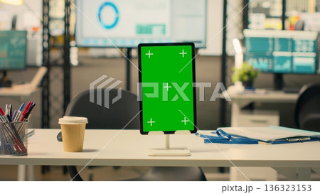 Tablet, vertical green screen, empty business office, organized work environment, modern furniture, office supplies, bright lighting, no people in workspace, interior desk setup. Tablet, vertical green screen, empty business office, organized work environment, modern furniture, office supplies, bright lighting, no people in workspace, interior desk setup. 136323153