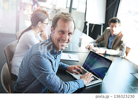 Smile, meeting and portrait of a businessman with a laptop for notes, email or planning at work. Expert, teamwork and a corporate worker typing on a pc for project management collaboration in office 136323230