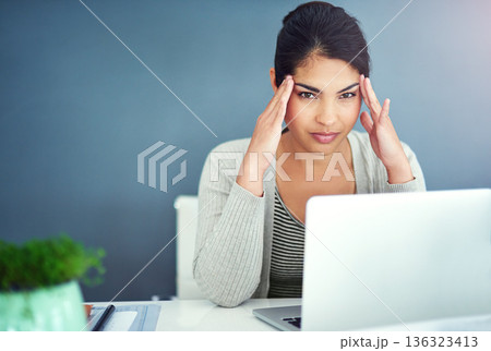 Business woman, headache and laptop in office with hands, portrait and anxiety at desk at startup. Young businesswoman, burnout and pain with fatigue, frustrated and stress for glitch in workplace 136323413