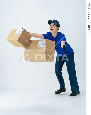 荷物を落とす作業服の女性の全身写真 136324515