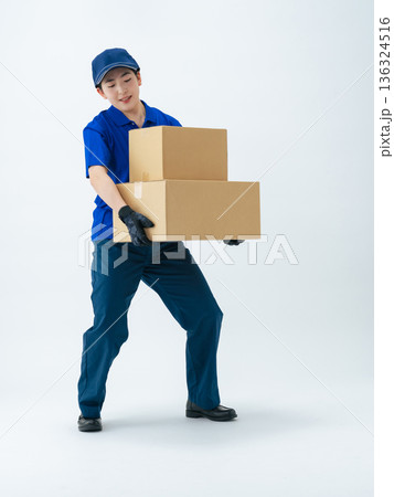 荷物を運ぶ作業服の女性の全身写真 136324516