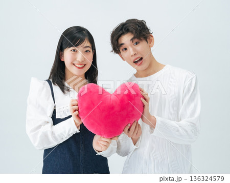 ハートクッションを持つ若い男女のカップルフォト 136324579