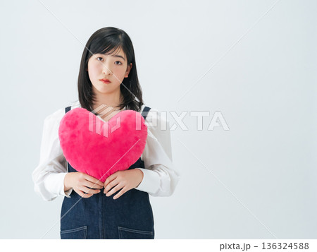 ハートクッションを持つ若い女性のポートレート ハートクッションを持つ若い女性のポートレート 136324588