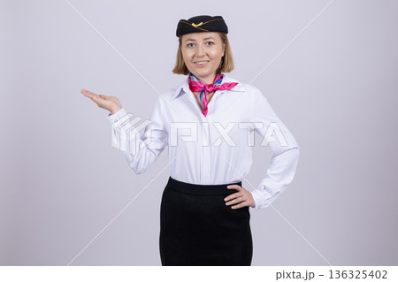 Stewardess in aviation uniform presenting copy space Stewardess in aviation uniform presenting copy space 136325402