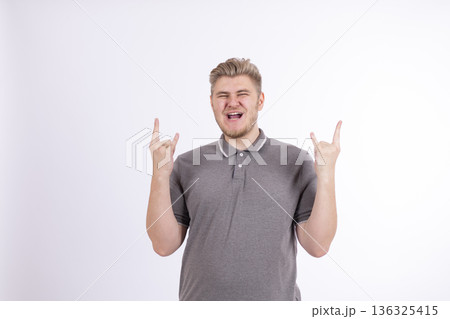 Excited young man pointing fingers up with happy expression Excited young man pointing fingers up with happy expression 136325415