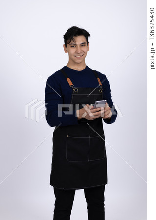 Professional male waiter using smartphone to take order 136325430