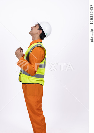 Construction worker in safety vest looking upwards Construction worker in safety vest looking upwards 136325457