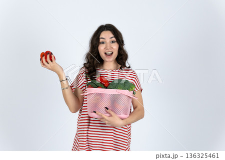 Woman holding basket with apples and red fruit 136325461