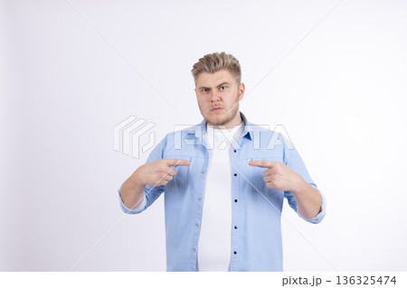 Happy young man pointing fingers at himself with pride 136325474