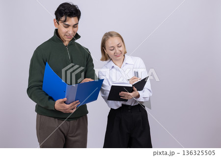 Young man and woman in uniform holding a blue folder 136325505