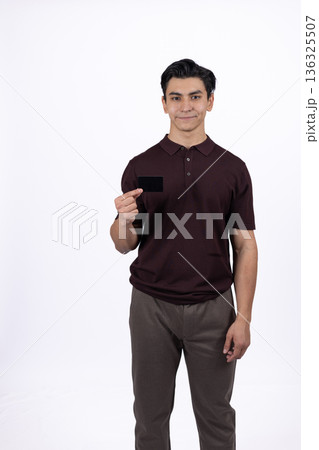 Young man in brown t-shirt pointing at camera with finger 136325507