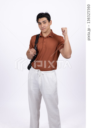 Man in orange polo shirt walking with blazer on shoulder 136325560