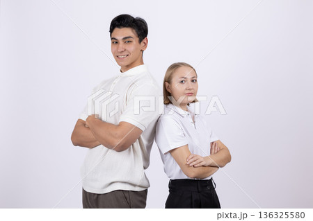 Young students standing back to back in uniform Young students standing back to back in uniform 136325580