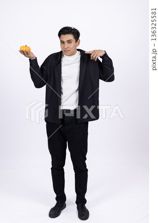 Young man in black shirt and trousers shrugging shoulders Young man in black shirt and trousers shrugging shoulders 136325581