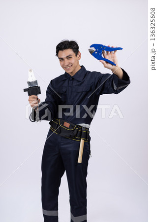 Technician in uniform holding industrial heat gun tool 136325608