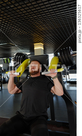 Strong man exercising with dumbbells in the gym Strong man exercising with dumbbells in the gym 136325617