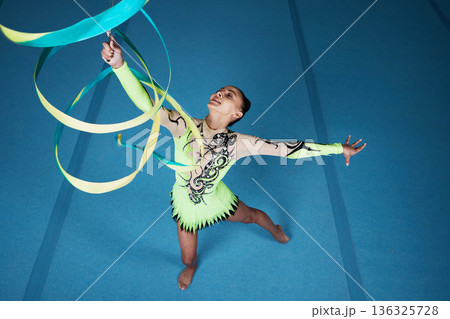 Dance, rhythmic gymnastics and woman in gym with ribbon in air, action with performance top view and fitness. Competition, athlete and female gymnast, creativity and art, routine and energy at arena Dance, rhythmic gymnastics and woman in gym with ribbon in air, action with performance top view and fitness. Competition, athlete and female gymnast, creativity and art, routine and energy at arena 136325728