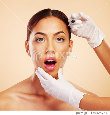 Surprise, woman or face in plastic surgery injection for facelift or cosmetics isolated on studio background. Forehead portrait, wow or shocked model with needle for skin beauty in medical procedure 136325734