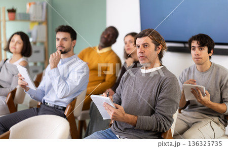 During lecture meeting, middle aged man pupil listen to teacher, write down summary. During lecture meeting, middle aged man pupil listen to teacher, write down summary. 136325735