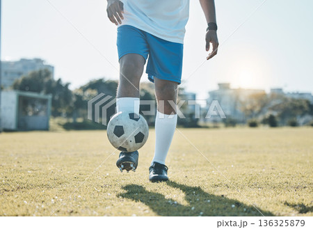 Training, field and legs of a man with a football for a game, fitness and learning sports. Grass, workout and feet of an athlete for a goal, exercise and playing professional soccer in nature Training, field and legs of a man with a football for a game, fitness and learning sports. Grass, workout and feet of an athlete for a goal, exercise and playing professional soccer in nature 136325879