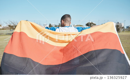 Germany, sports and man with a flag for soccer, motivation and training on a field. Back, fitness and professional athlete or person with representation of a country at a football game or competition Germany, sports and man with a flag for soccer, motivation and training on a field. Back, fitness and professional athlete or person with representation of a country at a football game or competition 136325927
