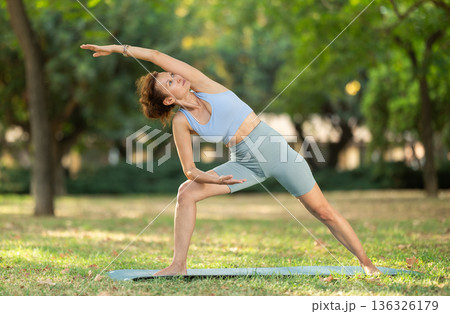 Adult woman doing yoga in park 136326179