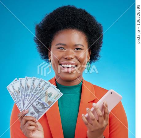 Black woman, money fan and phone in studio portrait with wow, surprise or happy for profit by blue background. African gen z girl, smartphone and cash with smile, winner or gambling app for giveaway Black woman, money fan and phone in studio portrait with wow, surprise or happy for profit by blue background. African gen z girl, smartphone and cash with smile, winner or gambling app for giveaway 136326398