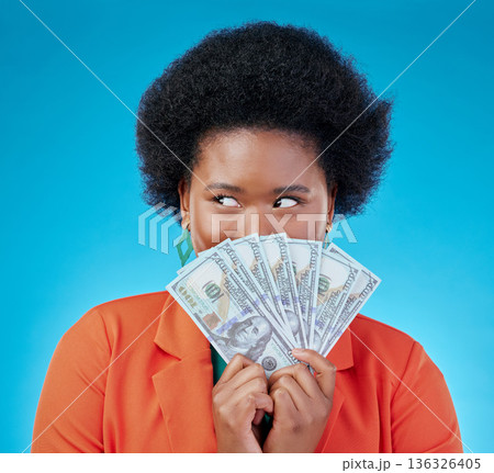 Cash, hide and a black woman lottery winner on a blue background in studio holding money for finance. Savings, investment or economy growth with a young female person excited for financial freedom Cash, hide and a black woman lottery winner on a blue background in studio holding money for finance. Savings, investment or economy growth with a young female person excited for financial freedom 136326405