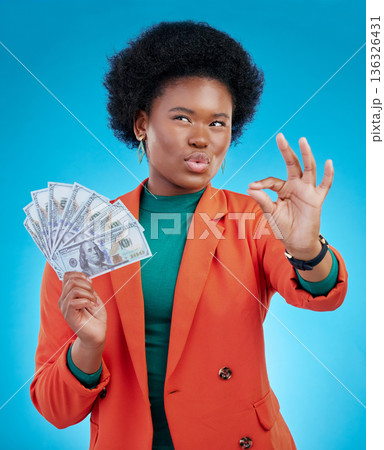 Money, okay sign and woman thinking of success, profit and sales deal with yes emoji on blue background. Financial ideas of rich, african person for cash, lottery goals or bonus achievement in studio 136326431