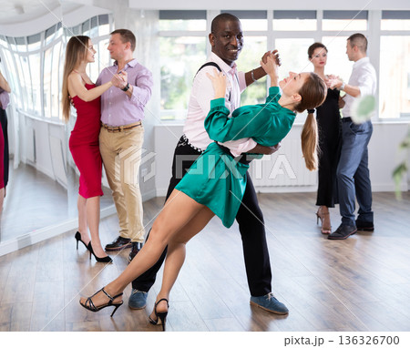 Middle-aged man and woman practicing waltz in dancing studio Middle-aged man and woman practicing waltz in dancing studio 136326700