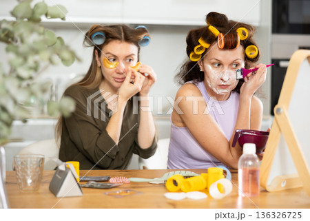 Women apply mask to their face with brush and use patches Women apply mask to their face with brush and use patches 136326725