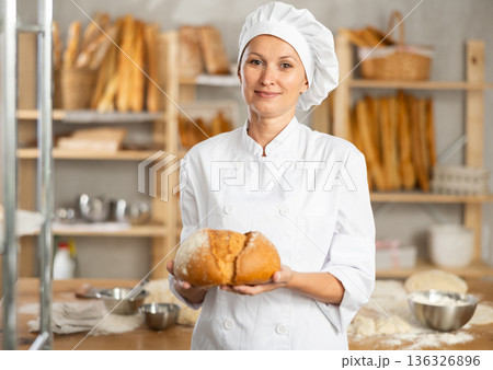 Positive female seller showing assortment of bakery 136326896