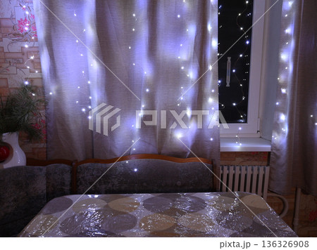 glowing garland on the curtains by the window 136326908