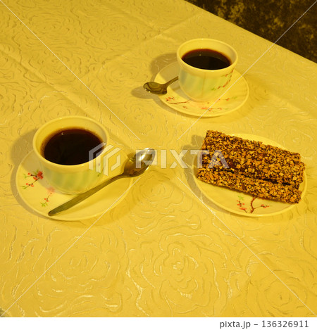 cups of coffee and dessert on a patterned surface 136326911
